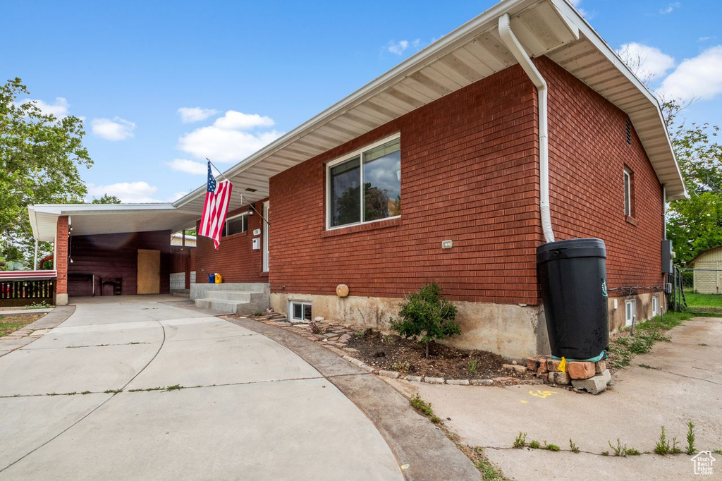 View of home\\\'s exterior featuring concrete driveway and an attached carport