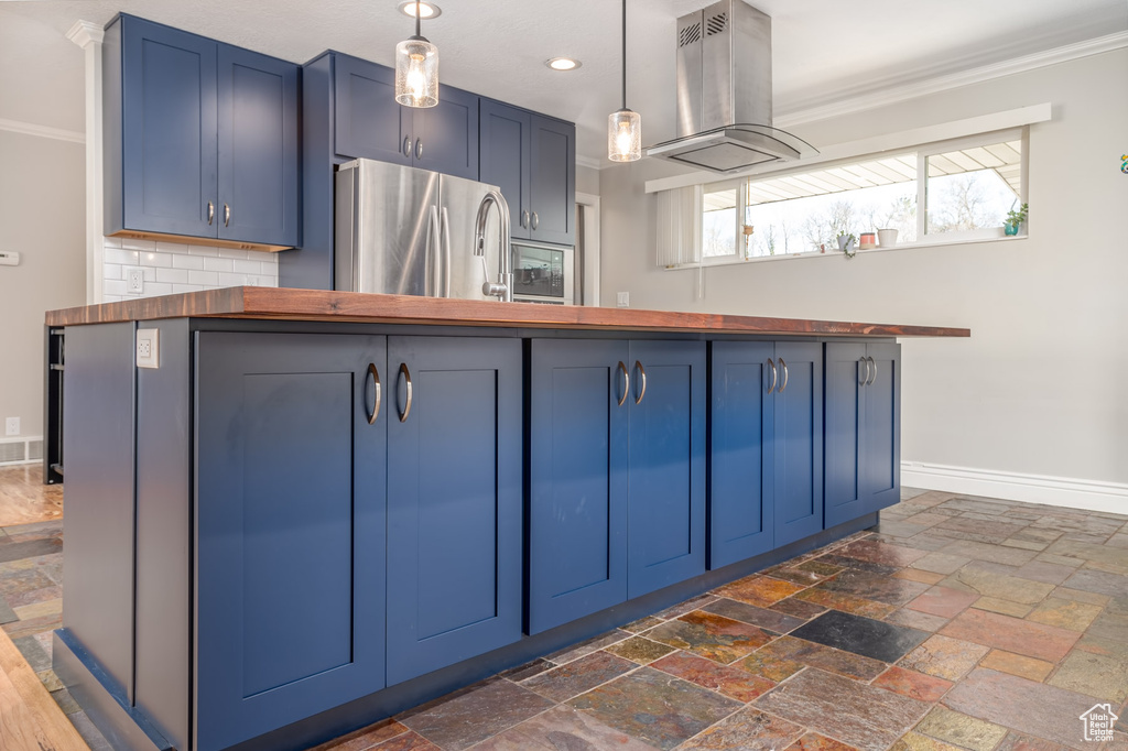 Kitchen with freestanding refrigerator, wood counters, island exhaust hood, blue cabinets, and ornamental molding
