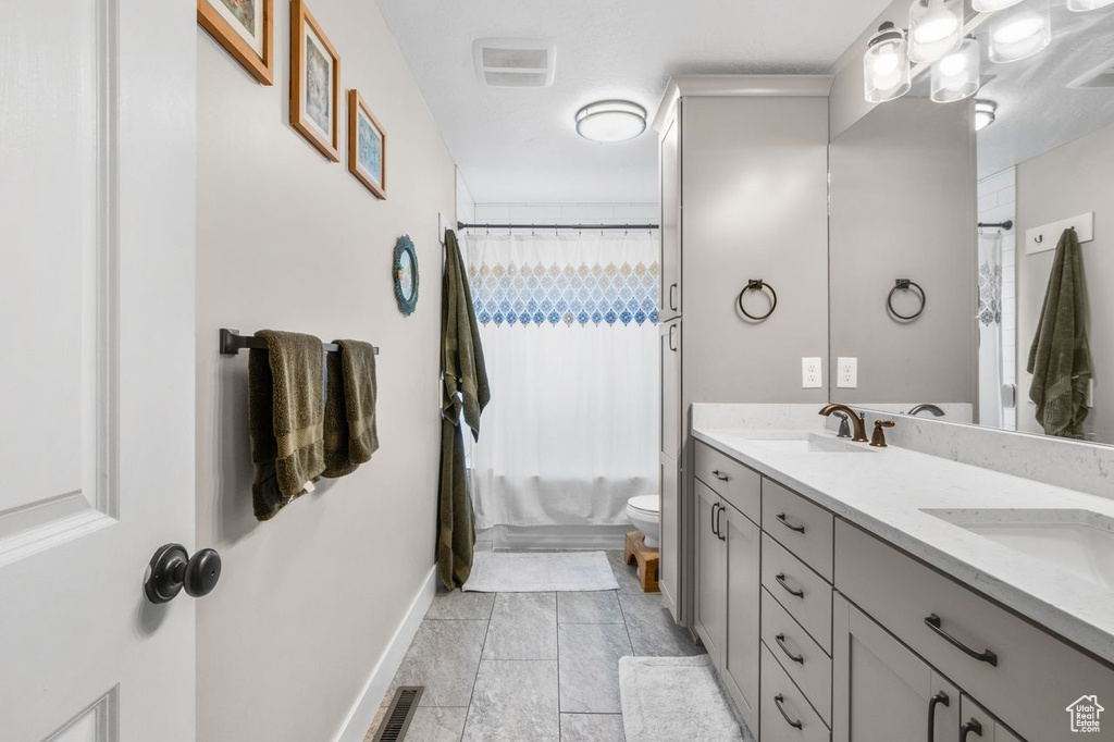 Full bath with double vanity and shower / tub combo with curtain