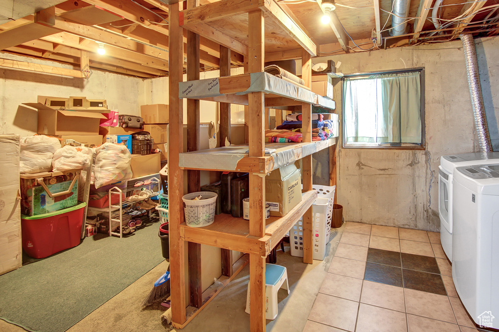 Basement with washer and clothes dryer and tile patterned flooring