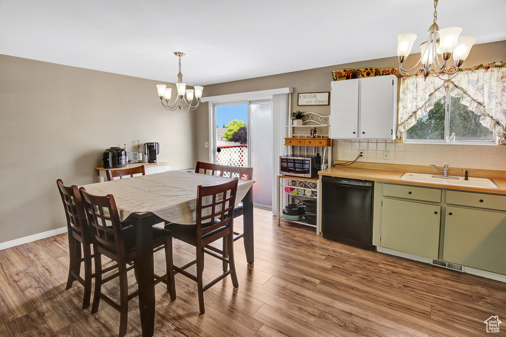 Dining room featuring a chandelier, dark wood finished floors, and healthy amount of natural light