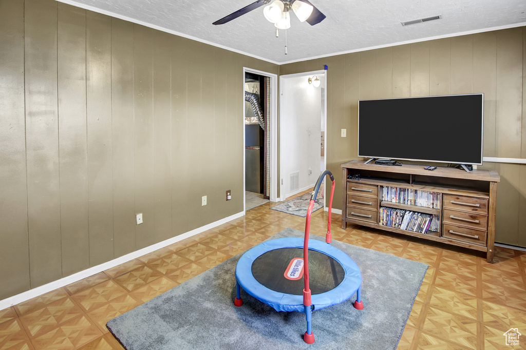 Rec room featuring ceiling fan, a textured ceiling, and ornamental molding