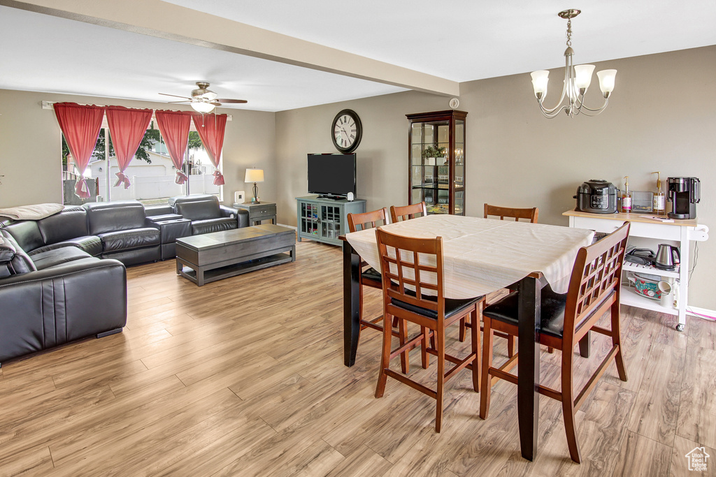 Dining space featuring a chandelier, light wood-type flooring, and ceiling fan