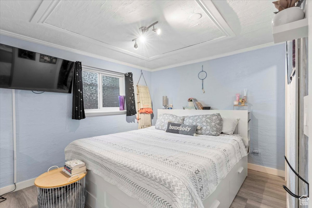 Bedroom featuring wood finished floors and ornamental molding