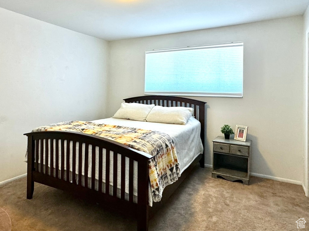 Bedroom featuring carpet flooring and baseboards