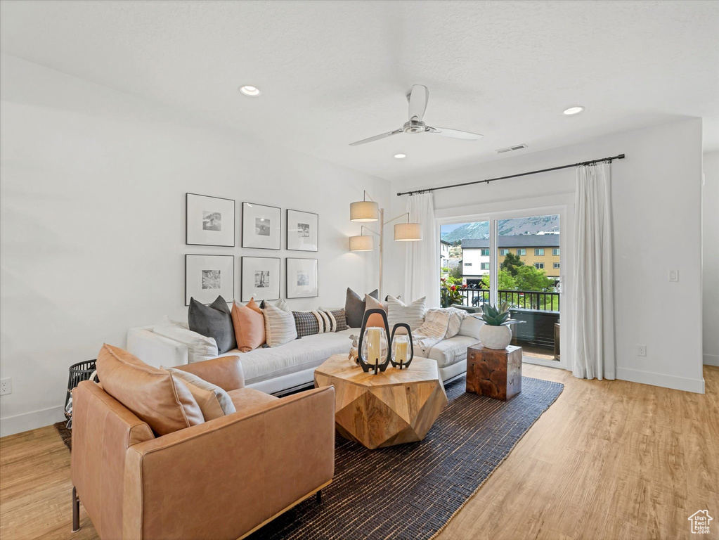 Living area with light wood-type flooring, a ceiling fan, and recessed lighting