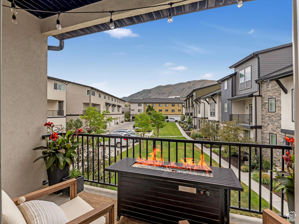 Balcony featuring an outdoor fire pit, a residential view, and a mountain view