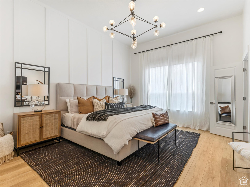 Bedroom featuring light wood-type flooring and a chandelier
