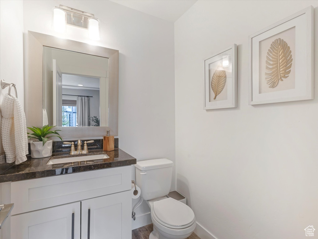 Half bath with vanity and wood finished floors