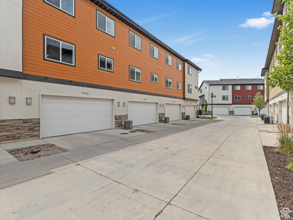 View of building exterior with a garage and driveway