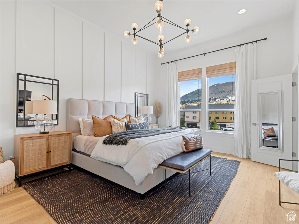 Bedroom with wood finished floors, a mountain view, and a chandelier