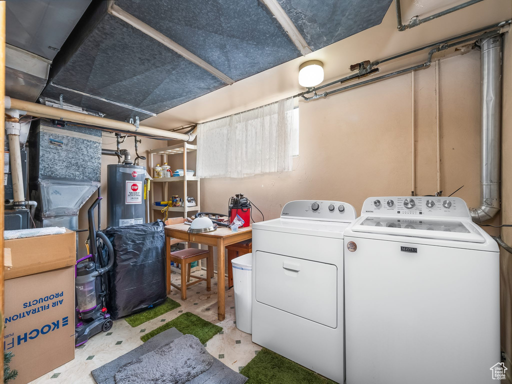 Unfinished basement with electric water heater and washer and clothes dryer