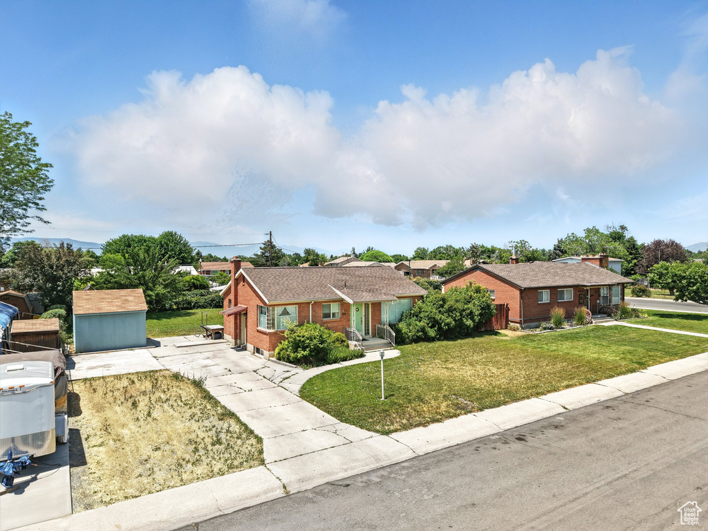 Ranch-style house featuring brick siding, a front lawn, and concrete driveway