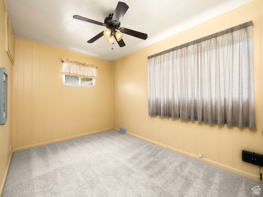 Unfurnished room featuring carpet flooring and a ceiling fan