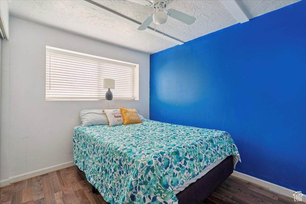 Bedroom with wood finished floors, a ceiling fan, and a textured ceiling