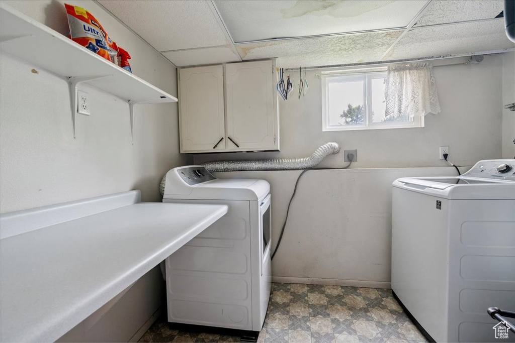 Washroom featuring cabinet space and washing machine and clothes dryer