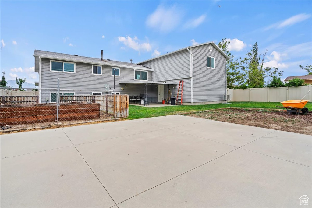 Rear view of house with a patio area and a fenced backyard