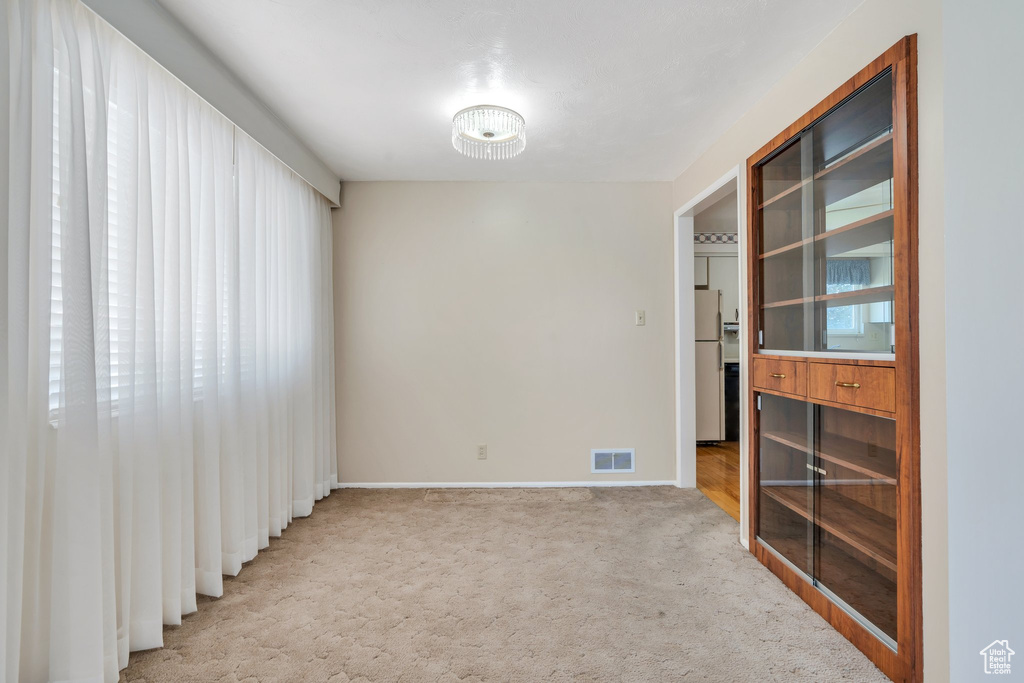 Carpeted empty room with baseboards