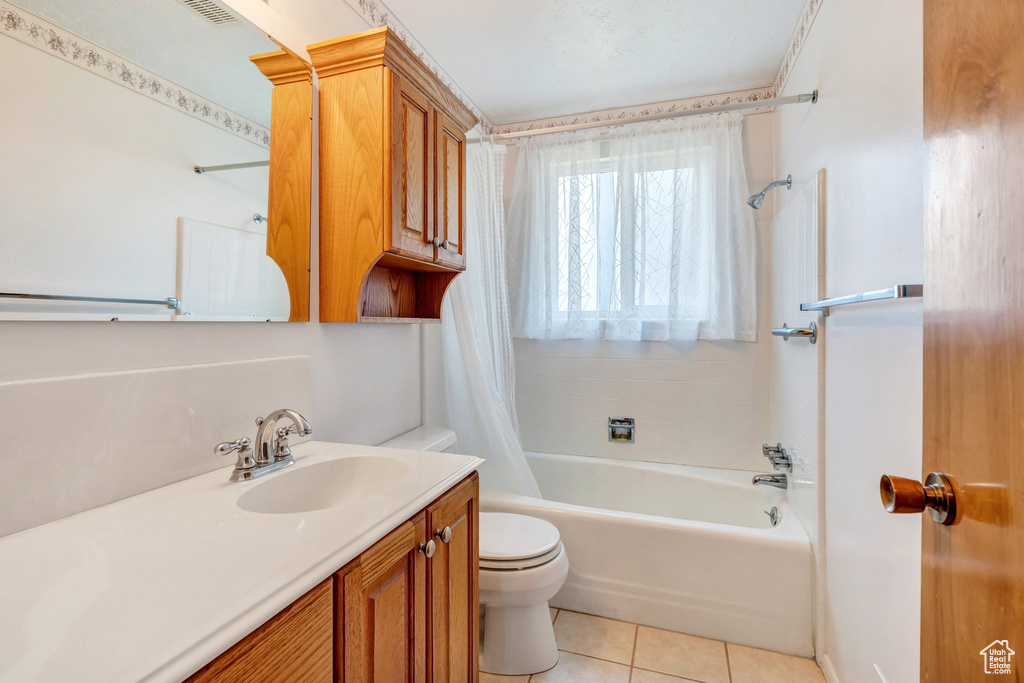 Bathroom featuring vanity, tile patterned flooring, and shower / tub combo