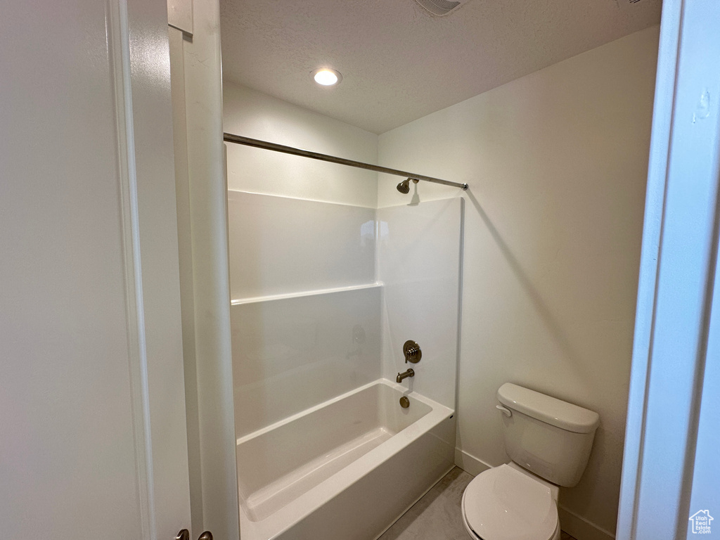Bathroom featuring  shower combination, recessed lighting, and a textured ceiling