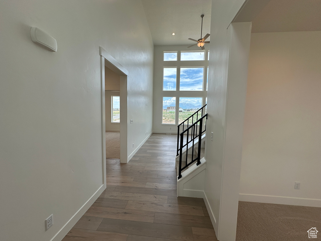 Corridor with hardwood / wood-style flooring, stairs, and recessed lighting