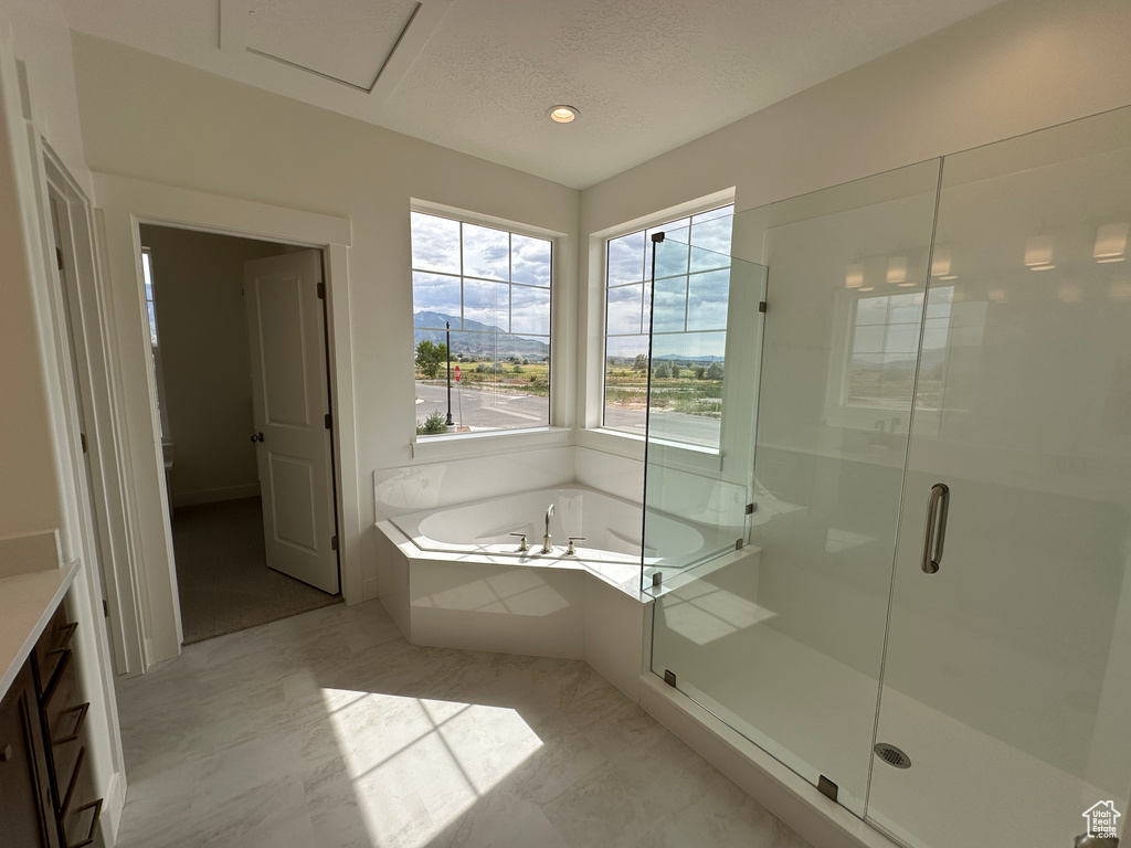 Full bath with a bath, a shower stall, a textured ceiling, vanity, and recessed lighting