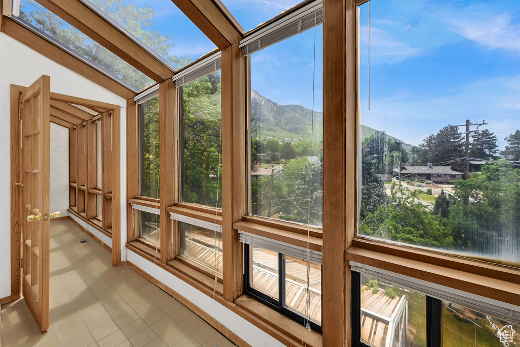 Unfurnished sunroom with tile patterned flooring and a mountain view