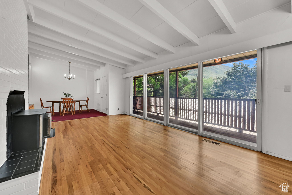 Unfurnished living room with wood finished floors and a chandelier