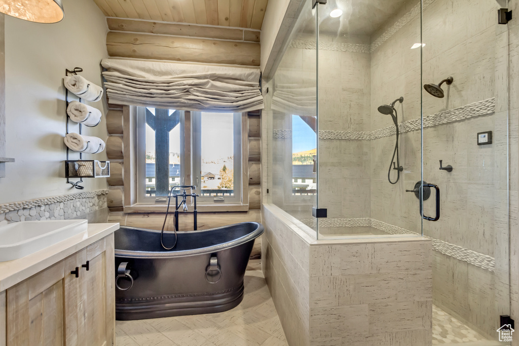 Full bathroom featuring a shower stall, a soaking tub, vanity, rustic walls, and wood ceiling