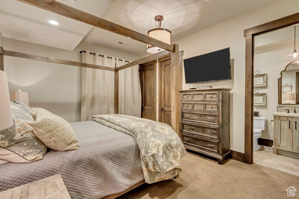 Bedroom featuring light carpet, ensuite bathroom, and recessed lighting
