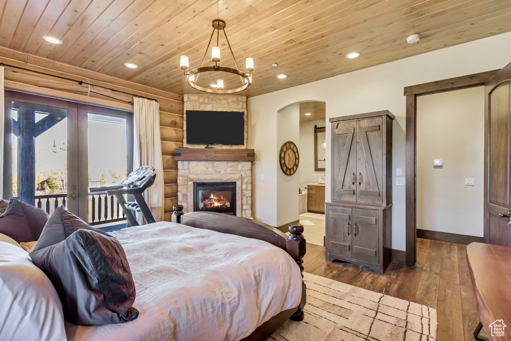 Bedroom with wooden ceiling, access to exterior, dark wood-type flooring, recessed lighting, and arched walkways