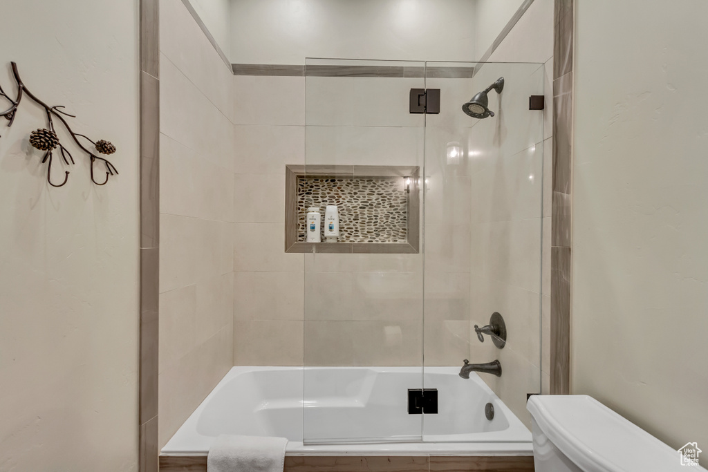 Bathroom featuring tiled shower / bath combo and toilet