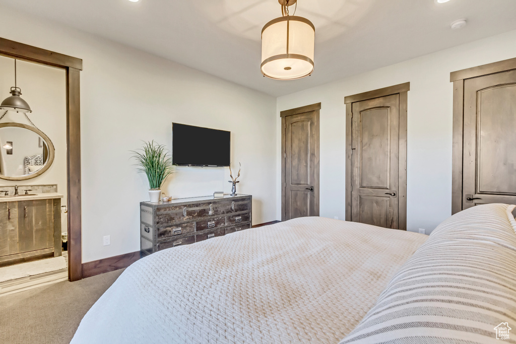 Bedroom with carpet floors, multiple closets, and connected bathroom