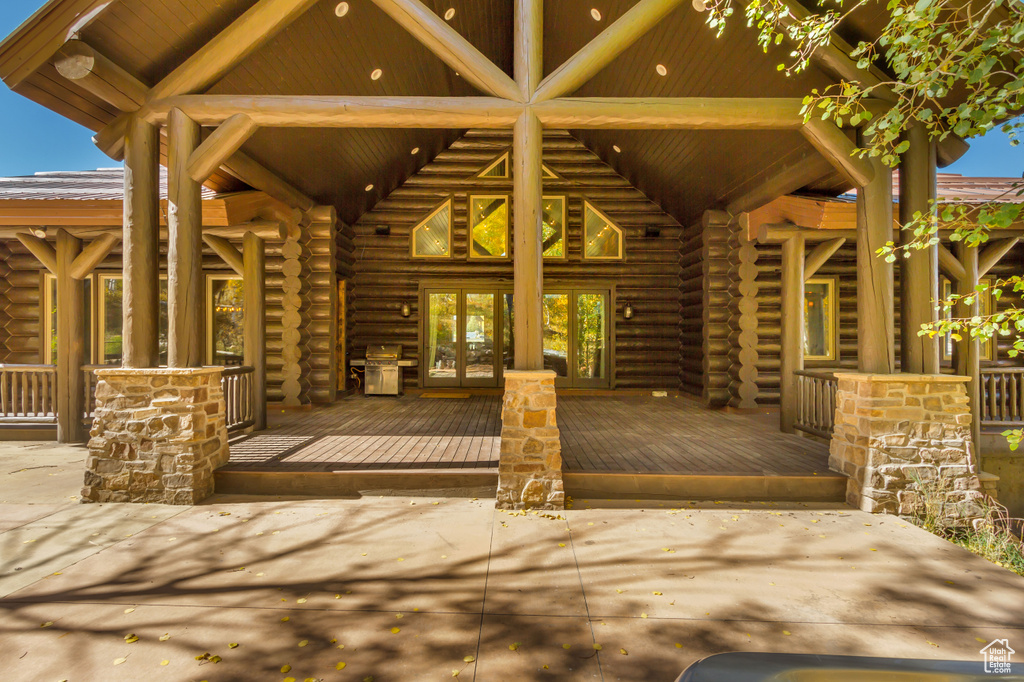 Entrance to property with french doors, log exterior, and a deck