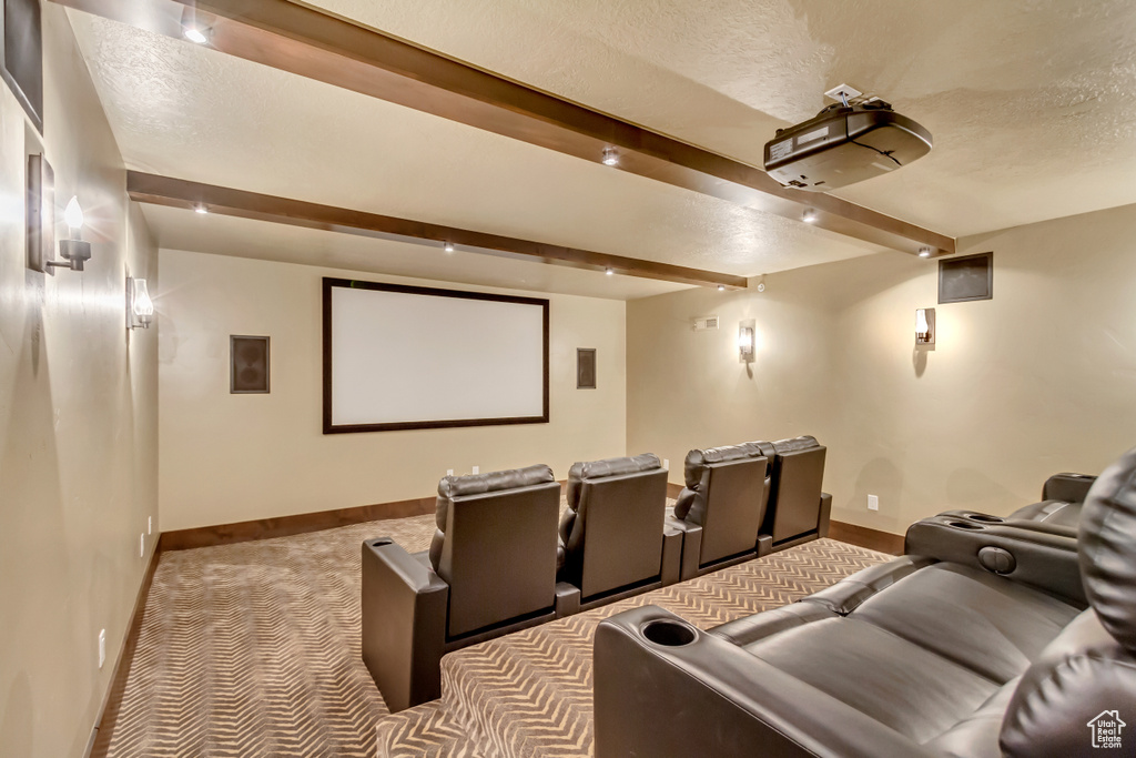 Cinema featuring beam ceiling, carpet, and a textured ceiling