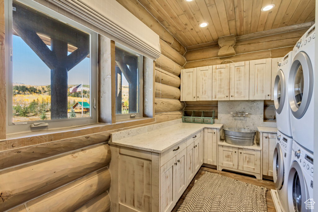 Laundry area featuring log walls, stacked washer / dryer, recessed lighting, wood ceiling, and wood finished floors