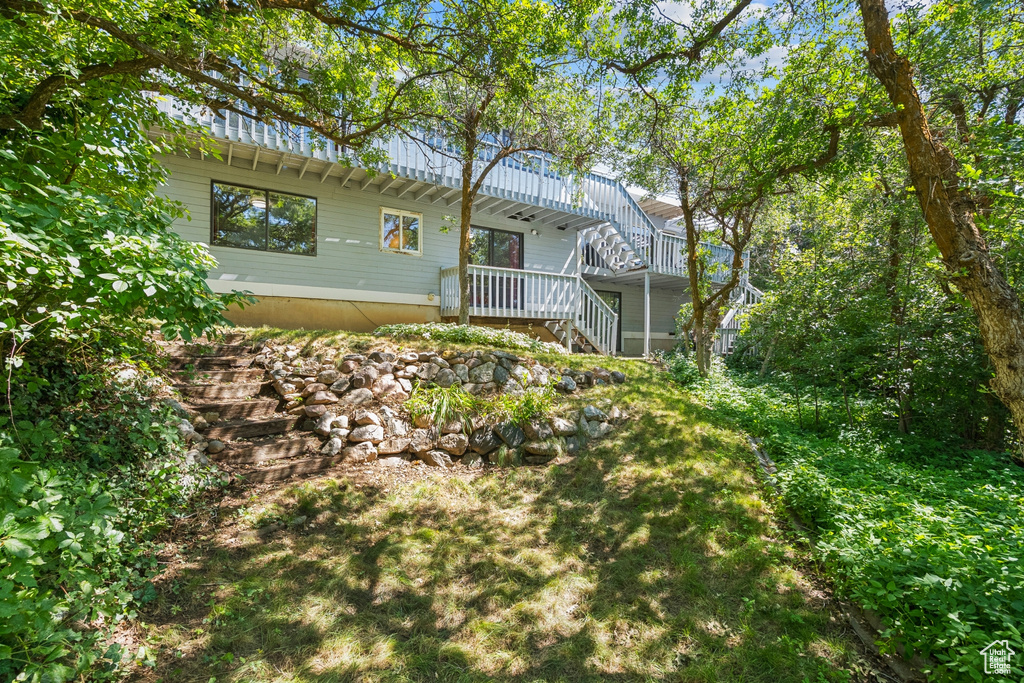 Rear view of property featuring stairs and a deck