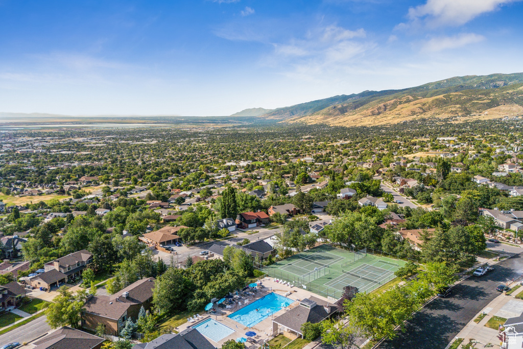 Aerial view of property and surrounding area with a pool area and a mountainous background