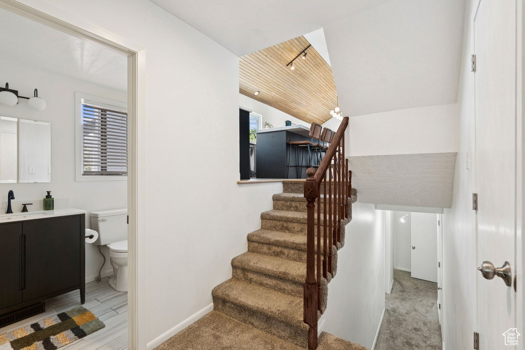 Staircase with baseboards and lofted ceiling