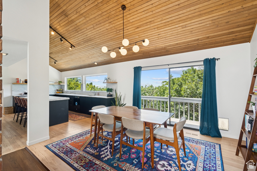 Dining room featuring rail lighting, wooden ceiling, light wood finished floors, and high vaulted ceiling
