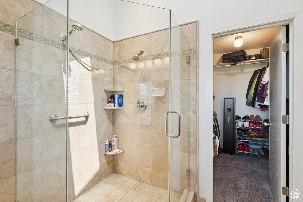 Full bathroom featuring a shower stall and a spacious closet