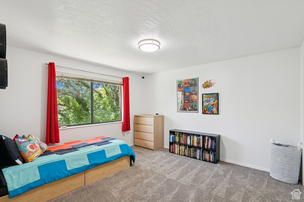Carpeted bedroom featuring a textured ceiling and baseboards