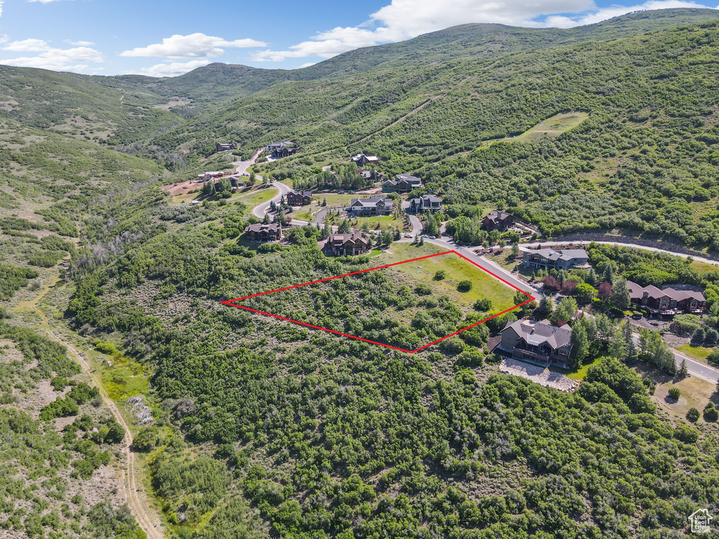 Aerial overview of property\\\'s location with a mountainous background and property boundaries highlighted