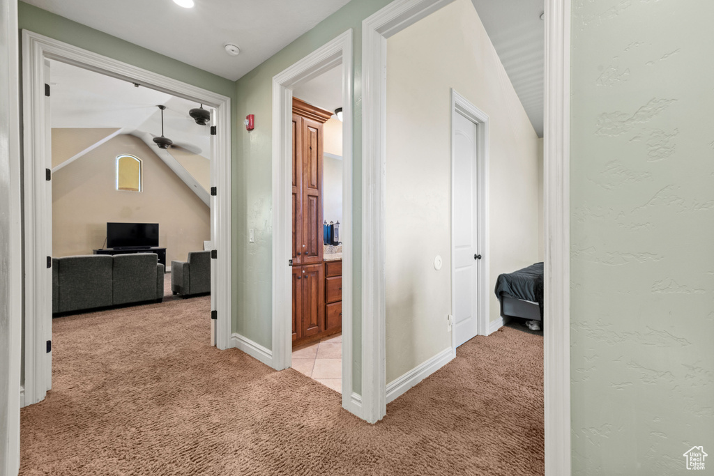 Hall with light colored carpet and vaulted ceiling