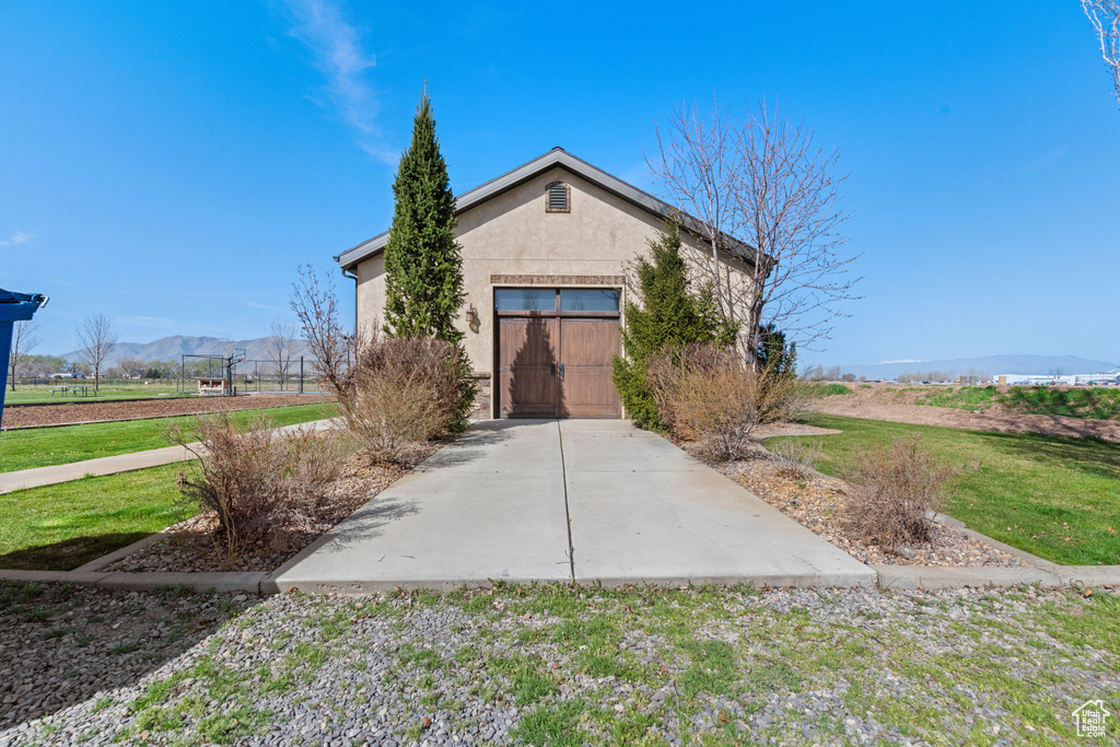 View of front of property with stucco siding, a mountain view, and a gate