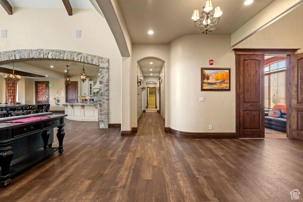 Foyer entrance featuring arched walkways, a chandelier, dark wood-style flooring, and recessed lighting