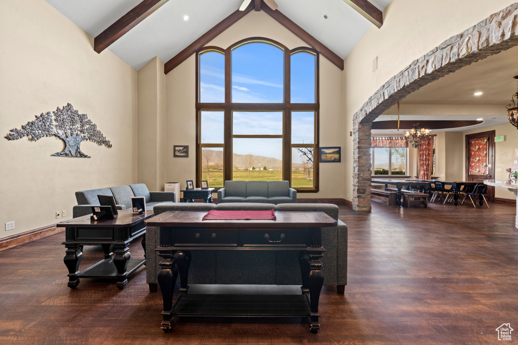 Living area featuring a chandelier, high vaulted ceiling, beamed ceiling, and wood finished floors