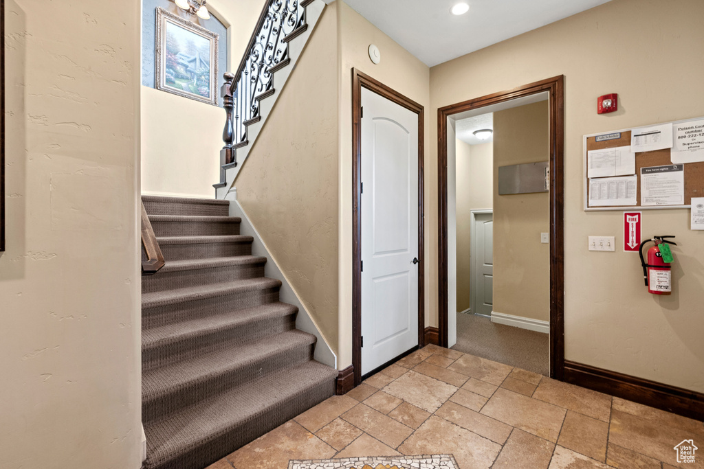Staircase with baseboards and stone tile flooring