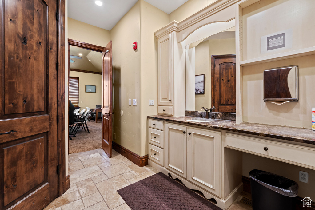 Bathroom with stone tile flooring, vanity, and recessed lighting