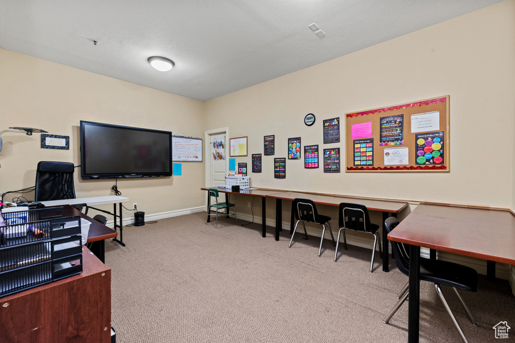 Carpeted home office featuring baseboards